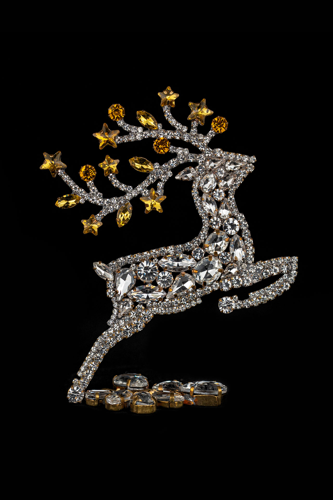 Decorative reindeer figurine with yellow rhinestones - facing right